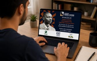 Homem está sentando em uma cadeira e está utilizando o notebook em cima de uma mesa, para se inscrever nos cursos ofertados pela Prefeitura.
